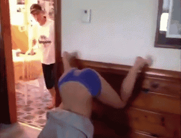 a woman in blue underwear is doing a handstand