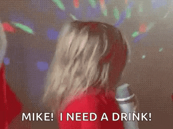 a woman is singing into a microphone and saying `` mike i need a drink ! ''