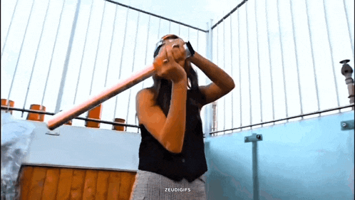 a woman is holding a bat in her hand and looking through it .