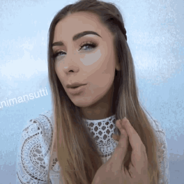 a woman wearing a white lace top has the name nimansutti on the bottom
