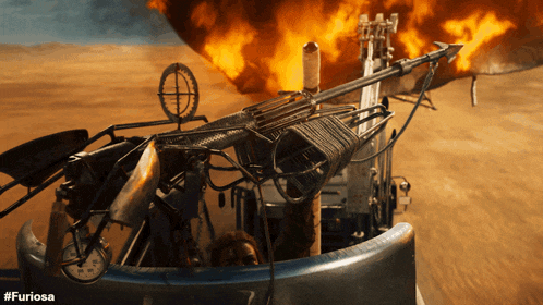 a movie poster for #furiosa shows a man sitting in a car