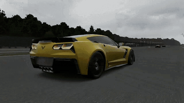 a yellow sports car with the letter v on the back is driving down a road