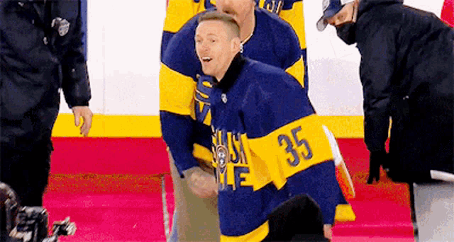 a man in a blue and yellow hockey jersey with the number 35 on it