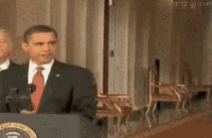 barack obama is standing at a podium giving a speech