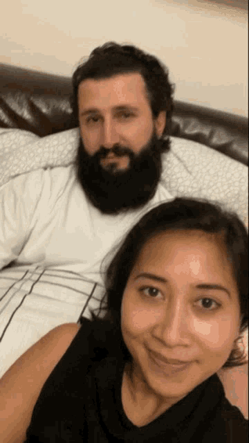 a man with a beard sits next to a woman
