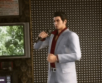 a man in a suit is singing into a microphone in a room .