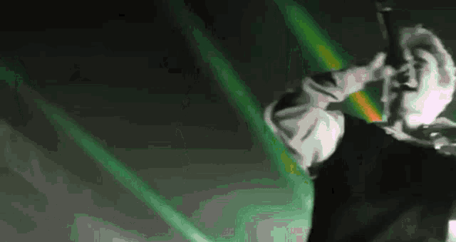 a man is singing into a microphone in front of a green background .