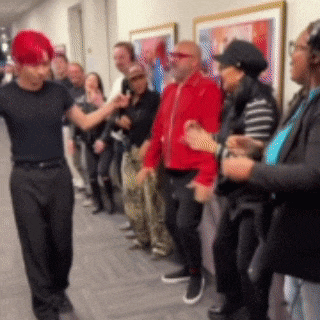 a man with red hair stands in front of a crowd of people