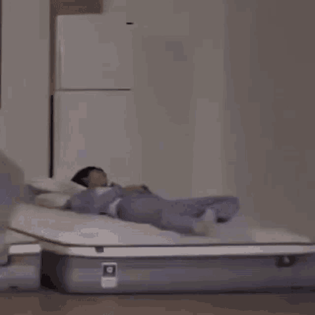 a person is sitting on a suitcase on a bed .