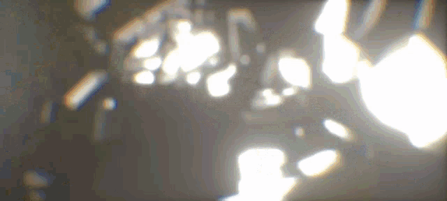 a blurred image of a person standing in a dark room with a light coming out of the ceiling .
