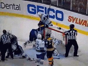 a hockey game is being played in front of an ad for geico