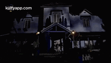 a large house is lit up at night with a website called kulfyapp.com in the background .