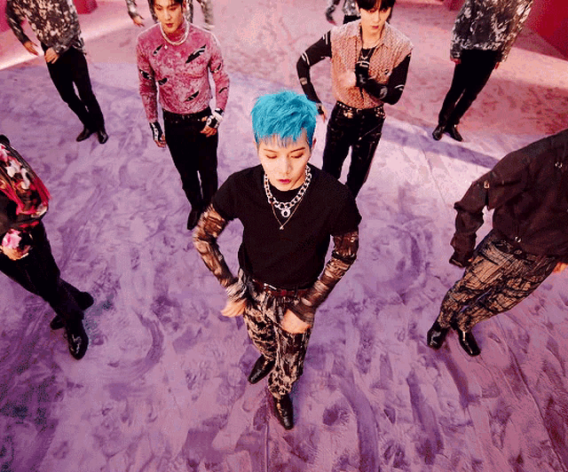 a group of young men are dancing on a purple carpet