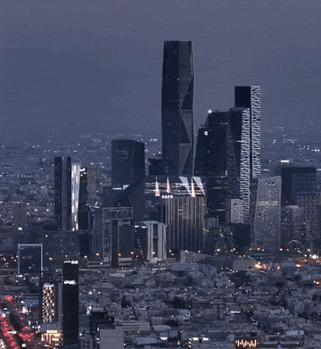 an aerial view of a city at night with a few buildings including one that says ' abc ' on it