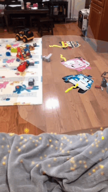 a blanket is laying on a wooden floor in a room filled with toys