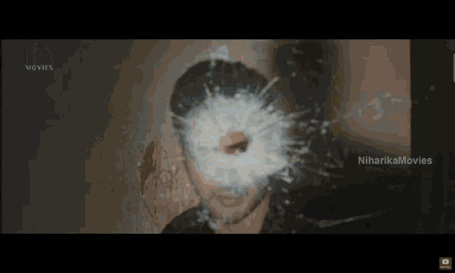 a bullet hole in a man 's face with niharika movies written on the bottom