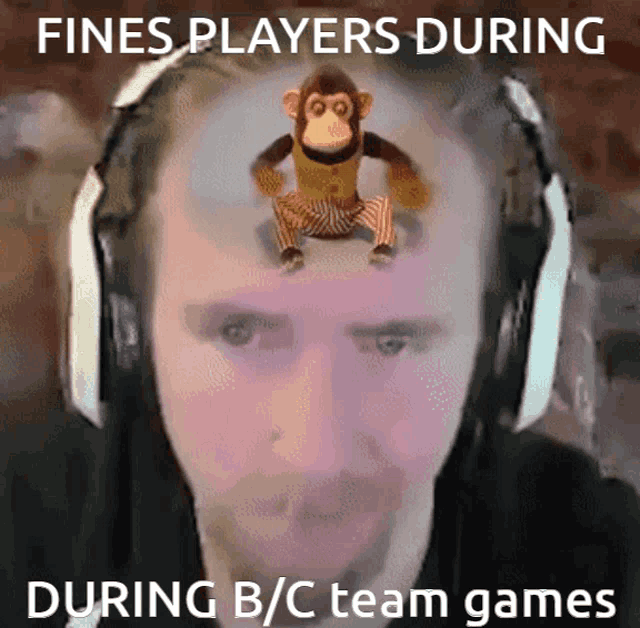 a man wearing headphones has a stuffed monkey on his head with the caption fines players during