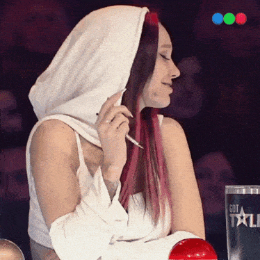 a woman with red hair is sitting in front of a sign that says got talent