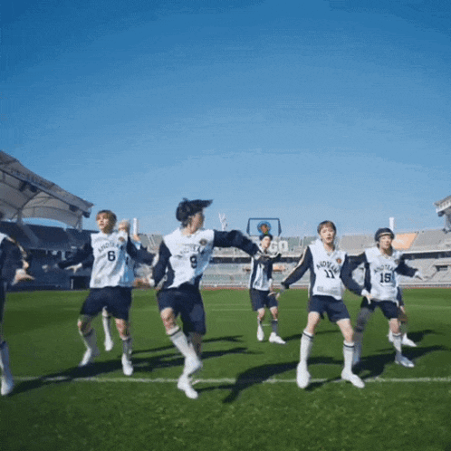 a group of soccer players are dancing on a field and one of them has the number 19 on their jersey