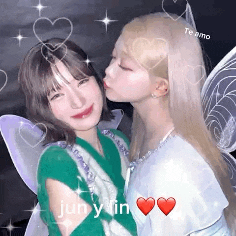 a couple of girls are kissing each other on the cheek .