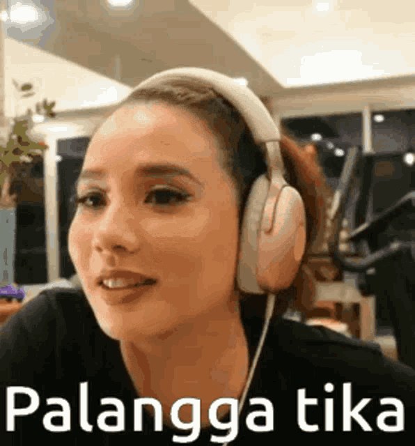 a woman wearing headphones is smiling and making a face .