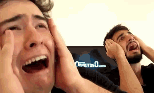 two men are covering their ears with their hands and one is crying .
