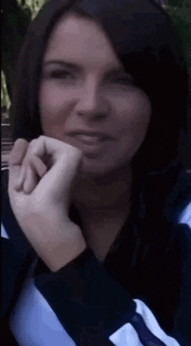 a close up of a woman 's face with her hand on her face