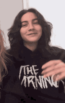 a woman wearing a hoodie that says the morning is smiling .