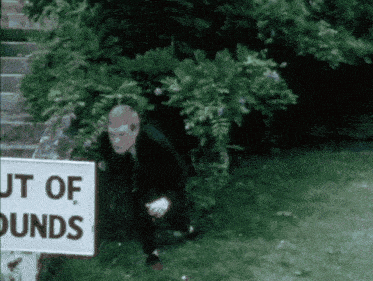 a man stands in front of a sign that says out ofbounds