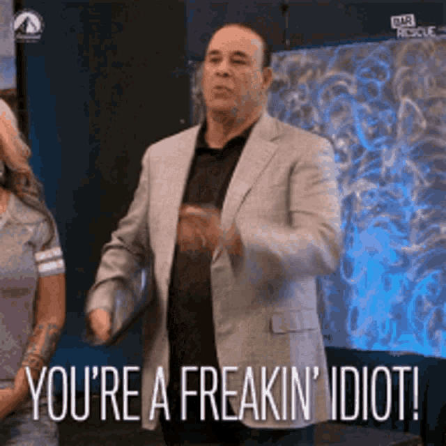 a man in a suit is saying `` you 're a freaking idiot ''