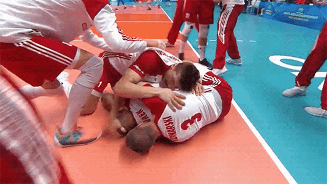a player with the number 3 on his jersey is laying on the floor