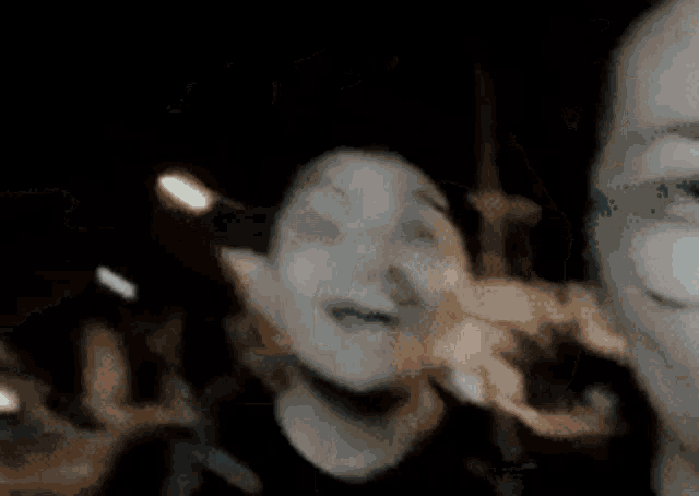 a blurry picture of a person 's face with a few lights in the background