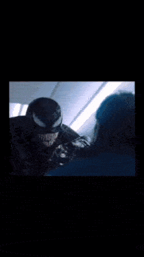 a man in a venom costume is standing next to another man
