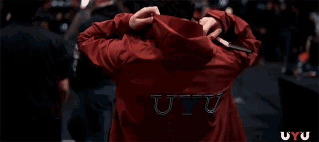 a man in a red hoodie with the word uyu on the back