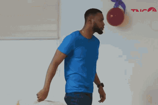a man in a blue shirt is throwing a yellow balloon to a woman in a white shirt .