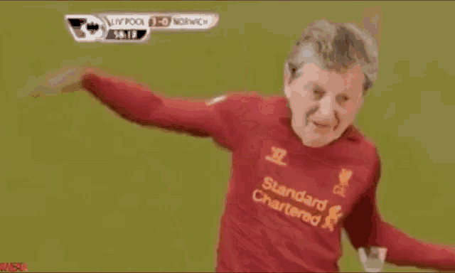 a man wearing a red standard chartered jersey is dancing