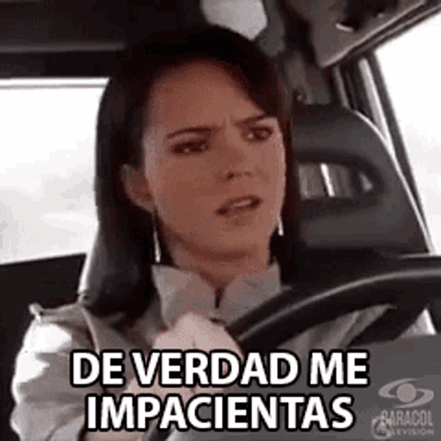 a woman is driving a car and making a funny face while saying `` de verdad me impacientas '' .