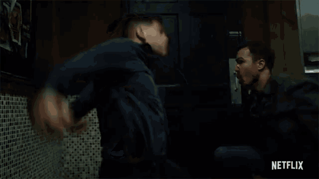 a man is fighting another man in a bathroom in a netflix trailer .