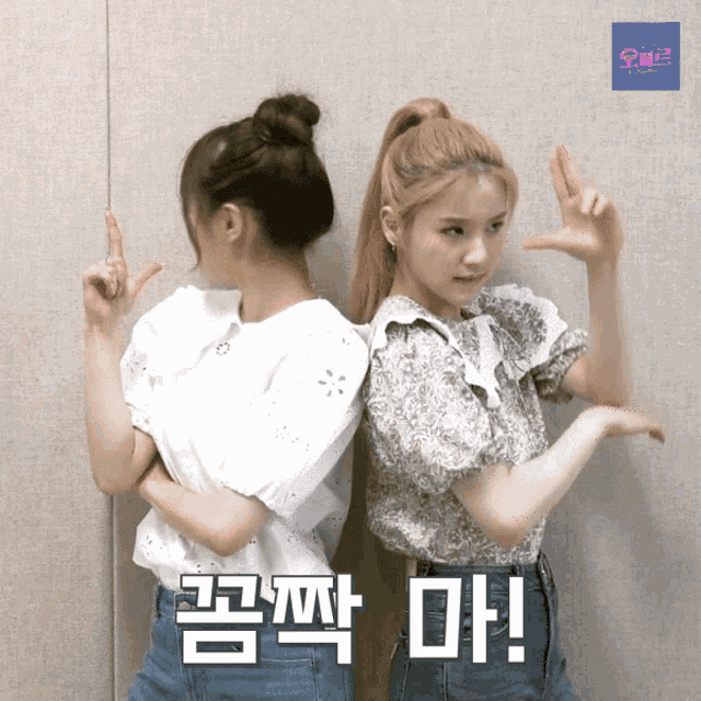 two girls are standing next to each other and one of them has a bun on her hair