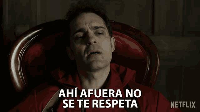 a man in a red jacket sits in a chair and says ahi afuera no se te respeta