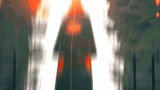 a blurred image of a person walking through a tunnel with trees in the background