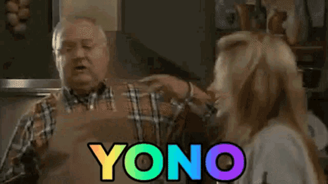 a man and a woman are standing in a kitchen and yono is written in rainbow colored letters