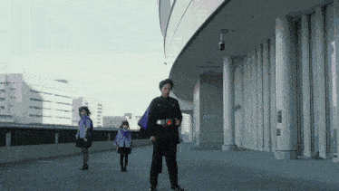 a man in a purple cape stands in front of two girls