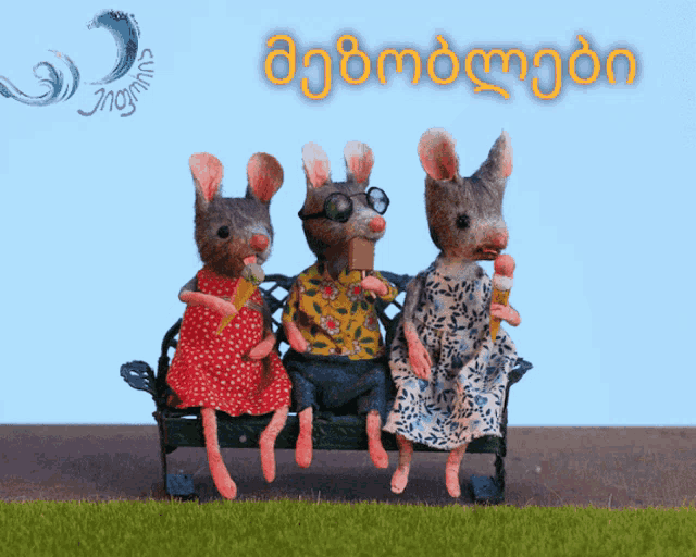 three stuffed mice are sitting on a bench with ice cream cones in their mouth