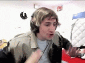 a man wearing headphones and a wig is sitting on a bed in a room .