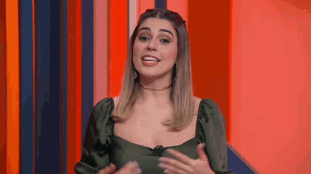 a woman in a green dress is talking to someone