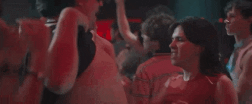a woman is screaming in a crowd of people at a party .