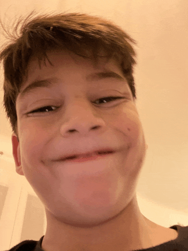 a close up of a young boy making a funny face