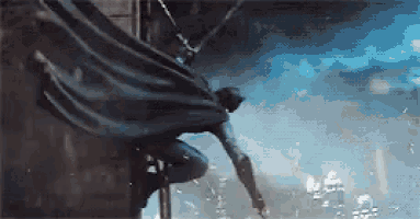 a man in a cape is flying through the air while climbing a pole .