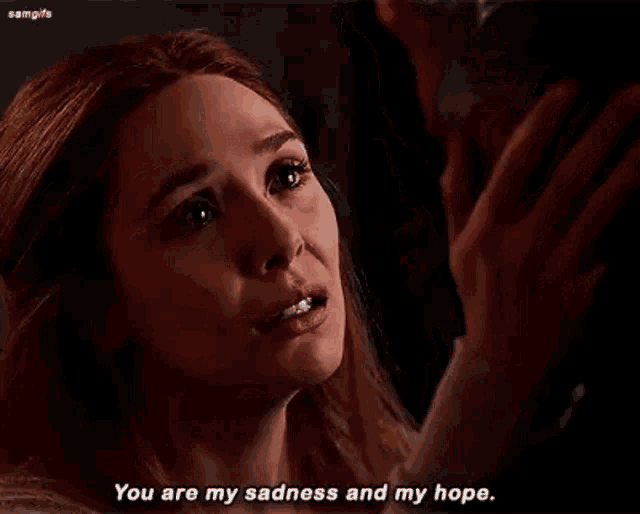 a woman is crying while holding a man 's hand .
